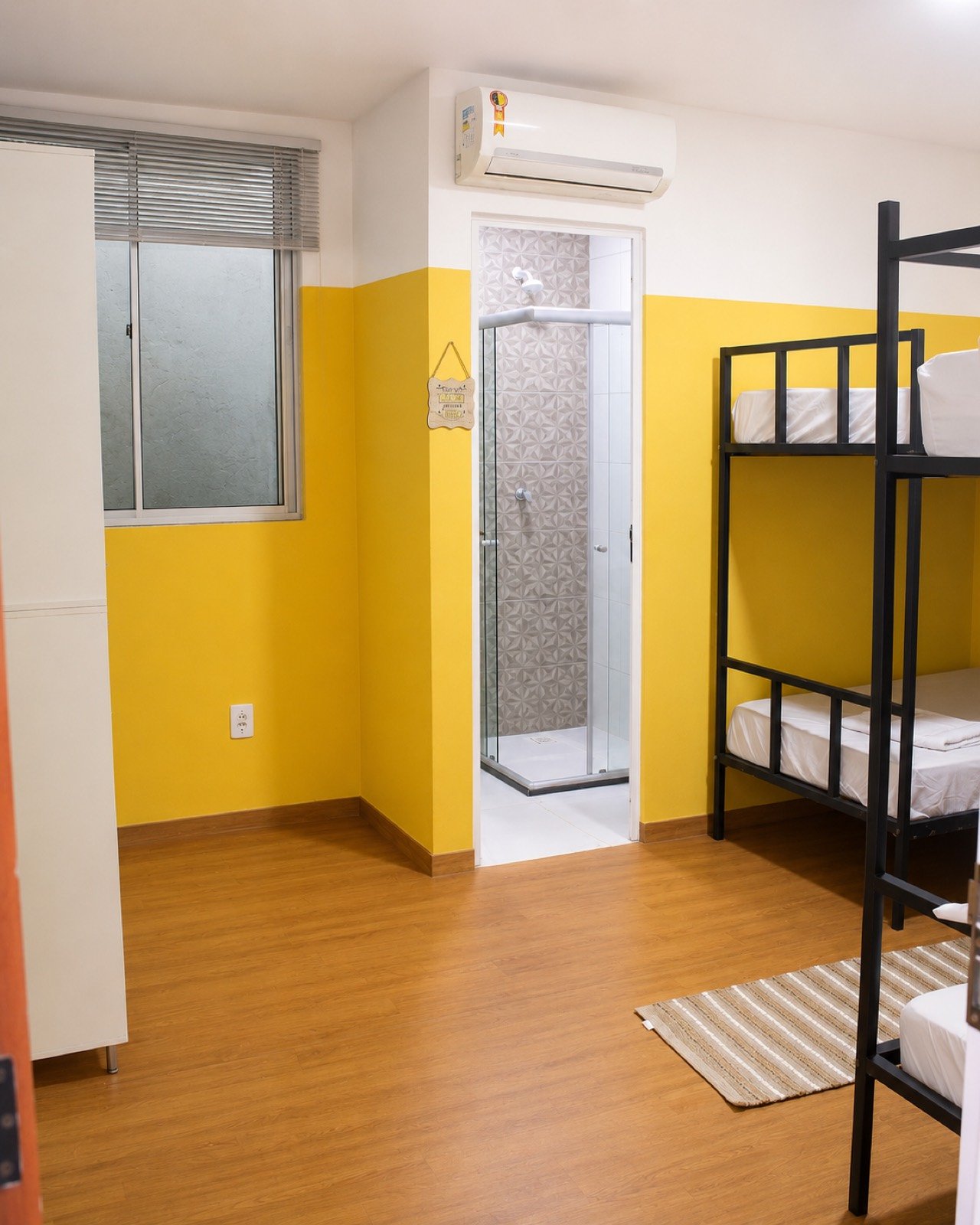 Quarto compartilhado do Cunhatã Hostel com beliche e banheiro privativo dentro do quarto